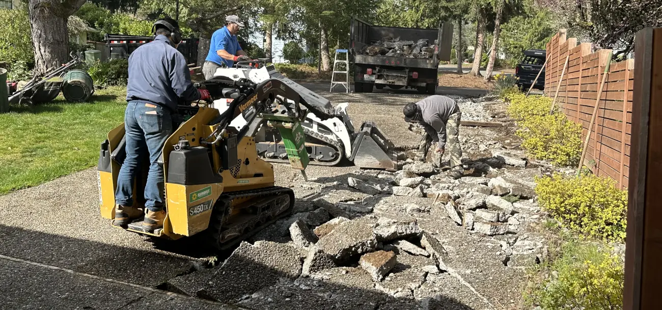 Workers preparing to replace a concrete driveway. Workers preparing to replace a concrete driveway.